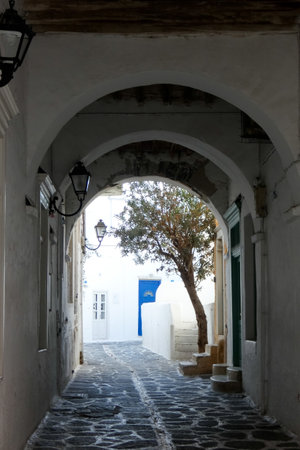 Picturesque alley with narrow tunnel with whitewashed walls, stone pavement, creating a charming Mediterranean atmosphere on the Greek islands, Greeceの写真素材