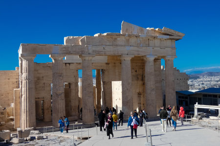 The Erechtheion, an ancient Greek temple located on the Acropolis in Athens, Greece, showcases its architectural marvel against a vibrant blue skyの写真素材