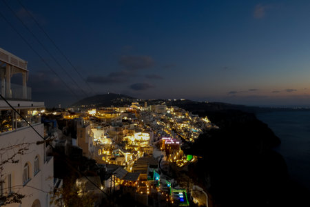 Night view of fira with illuminated buildings including the orthodox metropolitan cathedral and town hall in santorini, greeceの写真素材