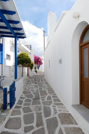 Local man walking away on a narrow cobblestone street in Paros town, Greeceの写真素材