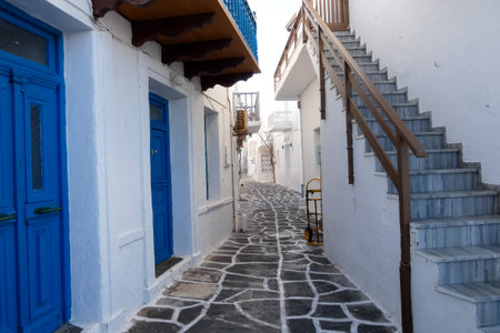 Local man walking away on a narrow cobblestone street in Paros town, Greeceの写真素材