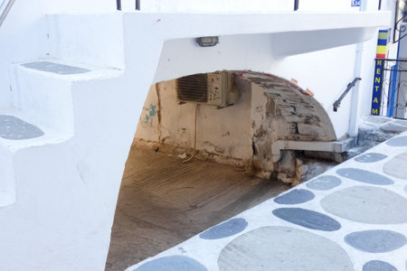 Picturesque alley with narrow tunnel with whitewashed walls, stone pavement, creating a charming Mediterranean atmosphere on the Greek islands, Greeceの写真素材