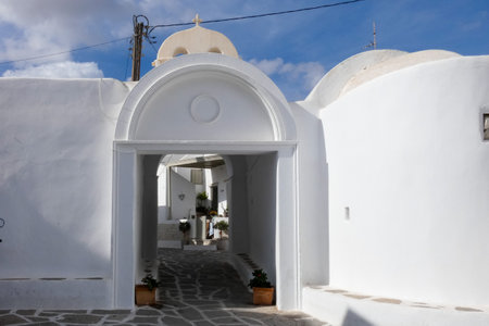 Local man walking away on a narrow cobblestone street in Paros town, Greece