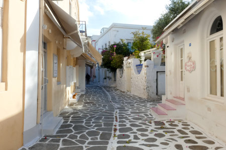 Local man walking away on a narrow cobblestone street in Paros town, Greeceの写真素材