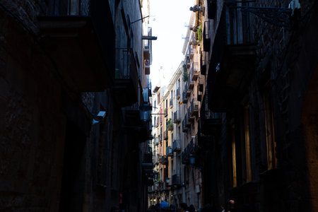 Flags with the Catalan flag hanging from balconies in a narrow street in the gothic quarter of Barcelona, Spainの写真素材