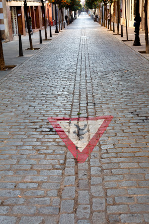Pedestrian yield painted sign on cobblestone street surface in perspectiveの写真素材