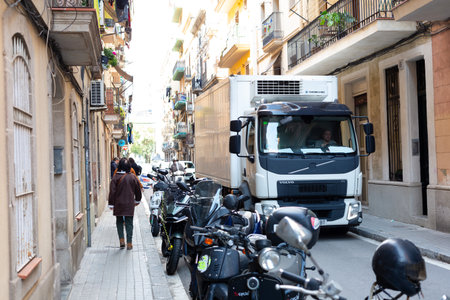 Residential buildings with balconies and hanging clothes in a narrow street of Barcelona, Spain