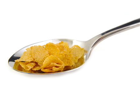 Bunch of corn flake cereals on a metal spoonの写真素材