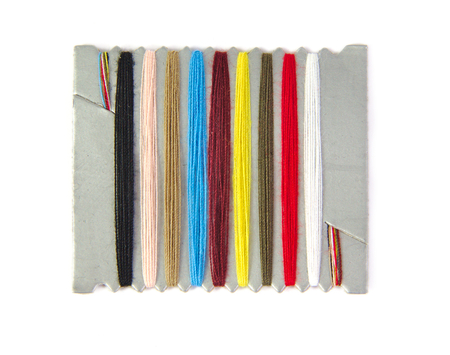 Closeup view of sewing threads multicolored on a white background