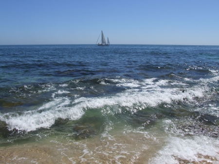 Wild sea with sailing boat on the horizonの写真素材