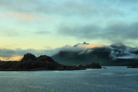 Norwegian fjord surrounded by mountains under the midnight sunの写真素材