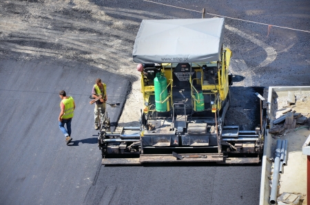 Machinery and workers paving a roadのeditorial素材