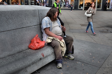 Homeless sitting on a bench drinking beerのeditorial素材