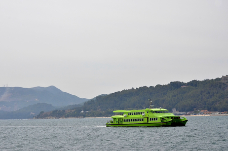 Green ferry sailing ridge near the Arrabida in Portugalのeditorial素材