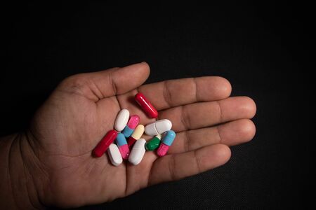 A man holds many different pills in his hand. Medicine conceptの写真素材
