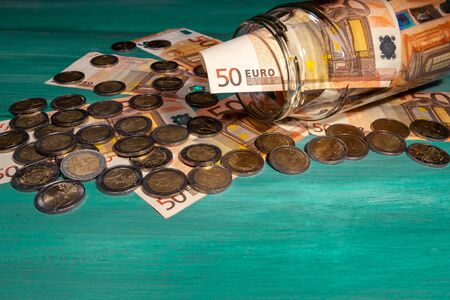 many eruos banknotes and coins inside glass jar on tableの写真素材