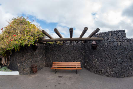 image of canarian patio with wooden bench, volcanic stone wall on the island of Lanzarote, spainのeditorial素材