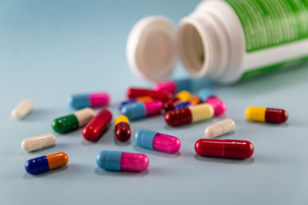image of multicolored pills and bottle on blue background