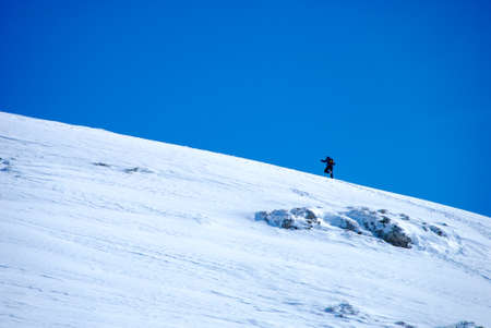 man climbing a mountain in winter