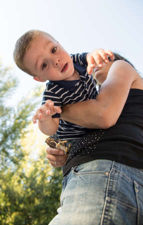 upside down boy taken by his motherの写真素材