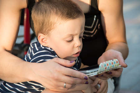 a boy and a young woman playing with a smartphoneの写真素材