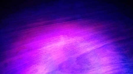 Purple light over a wooden surface creating a artistic colored textureの写真素材