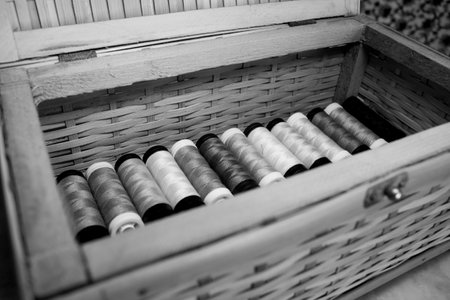Wooden box full of thread spools multicolored