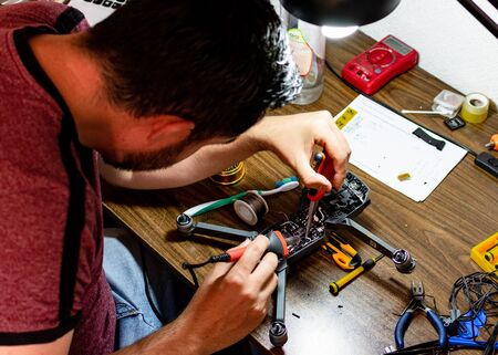 unrecognized guy repairing electronic board from damaged droneの写真素材
