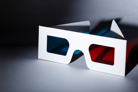 Movie at cinema concept. 3D glasses with red and blue lenses with soft shadow laying on white background.の写真素材
