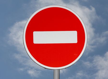 A stop sign on a blue sky background with some white clouds