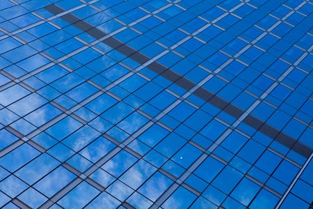 Reflection of a clear blue sky in a glass office building