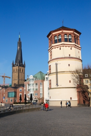 Unidentified people in the center of Dusseldorf, Germany, with the tower of the 14th Century St Lambertus church and the Schlossturm tower on February 11, 2012.のeditorial素材