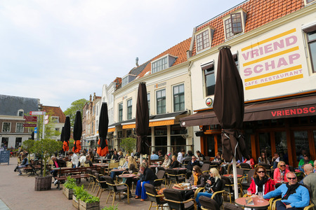 MIDDELBURG, THE NETHERLANDS - APRIL 12, 2014: People sitting outside on a terrace having a drink in the old center of Middelburg, capital of Zeeland province, the Netherlands.のeditorial素材