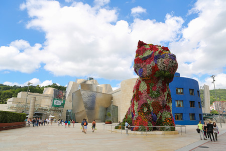 BILBAO, SPAIN - JULY 10, 2014: Unidentified people near the work of art 'Puppy' by Jeff Koons in front of the famous Guggenheim Museum in the center of Bilbao, Basque country, Spain.のeditorial素材