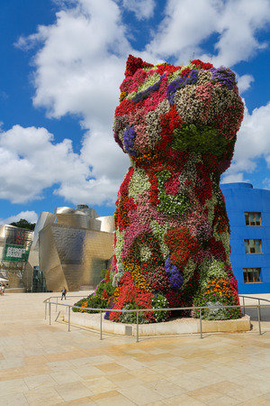 BILBAO, SPAIN - JULY 10, 2014: Unidentified people near the work of art 'Puppy' by Jeff Koons in front of the famous Guggenheim Museum in the center of Bilbao, Basque country, Spain.のeditorial素材