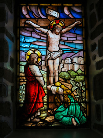 SAN ANDRES DE TEXEIDO, SPAIN - JULY 17, 2014: Stained glass window depicting the Crucifixion in the church of San Andres de Texeido, a famous Galician pilgrimage place in the Rias Altas region. This window was created more than 100 years ago, no property のeditorial素材