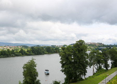 View on the border town Valenca do Minho and a small boat on the Minho river, the natural border between Portugal and Spain, as seen from Tui, Galicia, Spain.の写真素材