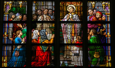 'S HERTOGENBOSCH, THE NETHERLANDS - JULY 23, 2011: Stained Glass Window depicting a saint performing the sacrament of Holy Communion in Den Bosch Cathedral, North Brabant.のeditorial素材