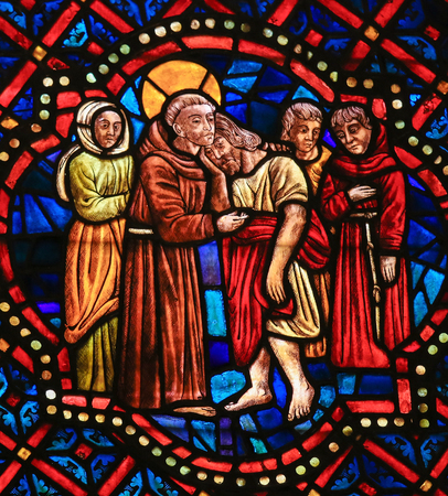 LEON, SPAIN - AUGUST 12, 2014: Stained Glass window depicting a Christian Saint hugging Christ in...