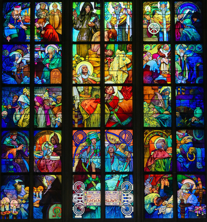 PRAGUE, CZECH REPUBLIC - APRIL 2, 2016: Stained Glass window of the Czech Patron Saint St. Wenceslas with his grandmother St. Ludmila surrounded by episodes from the lives of Saints Cyril and Methodius  in St. Vitus Cathedral, Prague, designed by Alphonseのeditorial素材