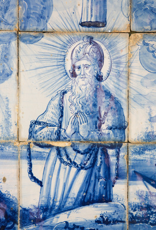 Azulejo tilework in Coimbra, Portugal, depicting a praying Saint in chainsのeditorial素材