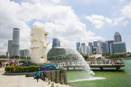 Marina Bay, Singapore - April 13, 2018: The Merlion, unofficial mascot of Singapore, half-fish and half-lion, at Marina Bay with the Singapore skyline in the background.のeditorial素材