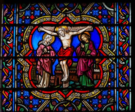 Stained Glass in the Cathedral of Notre Dame, Paris, France, depicting Jesus on the Cross, with St John and Mother Mary.の写真素材