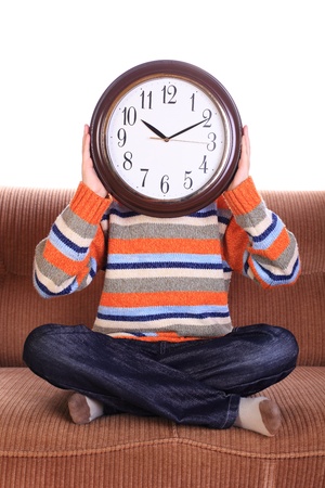 Young child with big clock covering faceの写真素材