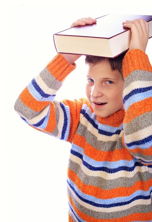 Student child with a book on his head isolated over whiteの写真素材
