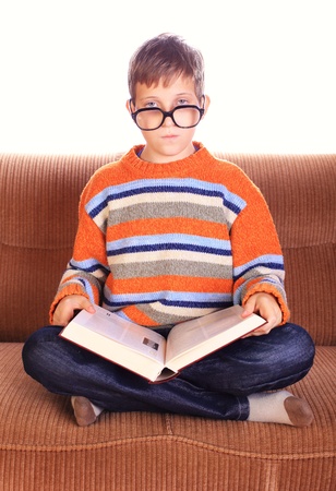 Young child sitting on sofa with bookの写真素材