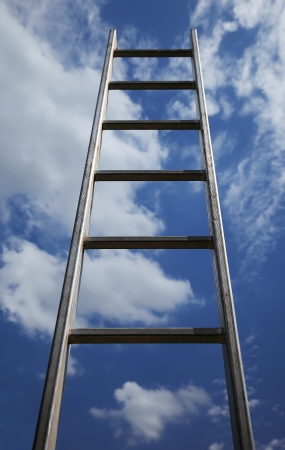 Ladder reaching into a blue sky and cloudsの写真素材