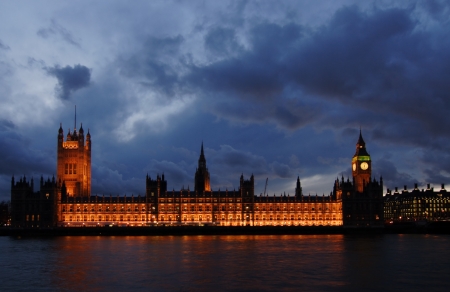 The famous landmarks of London  The Parliament, the Big Ben and the Thames by night の写真素材