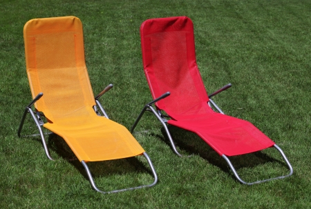 Red and yellow sunbed on grass outdoorの写真素材