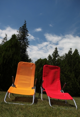 Red and yellow sunbed on grass outdoorの写真素材